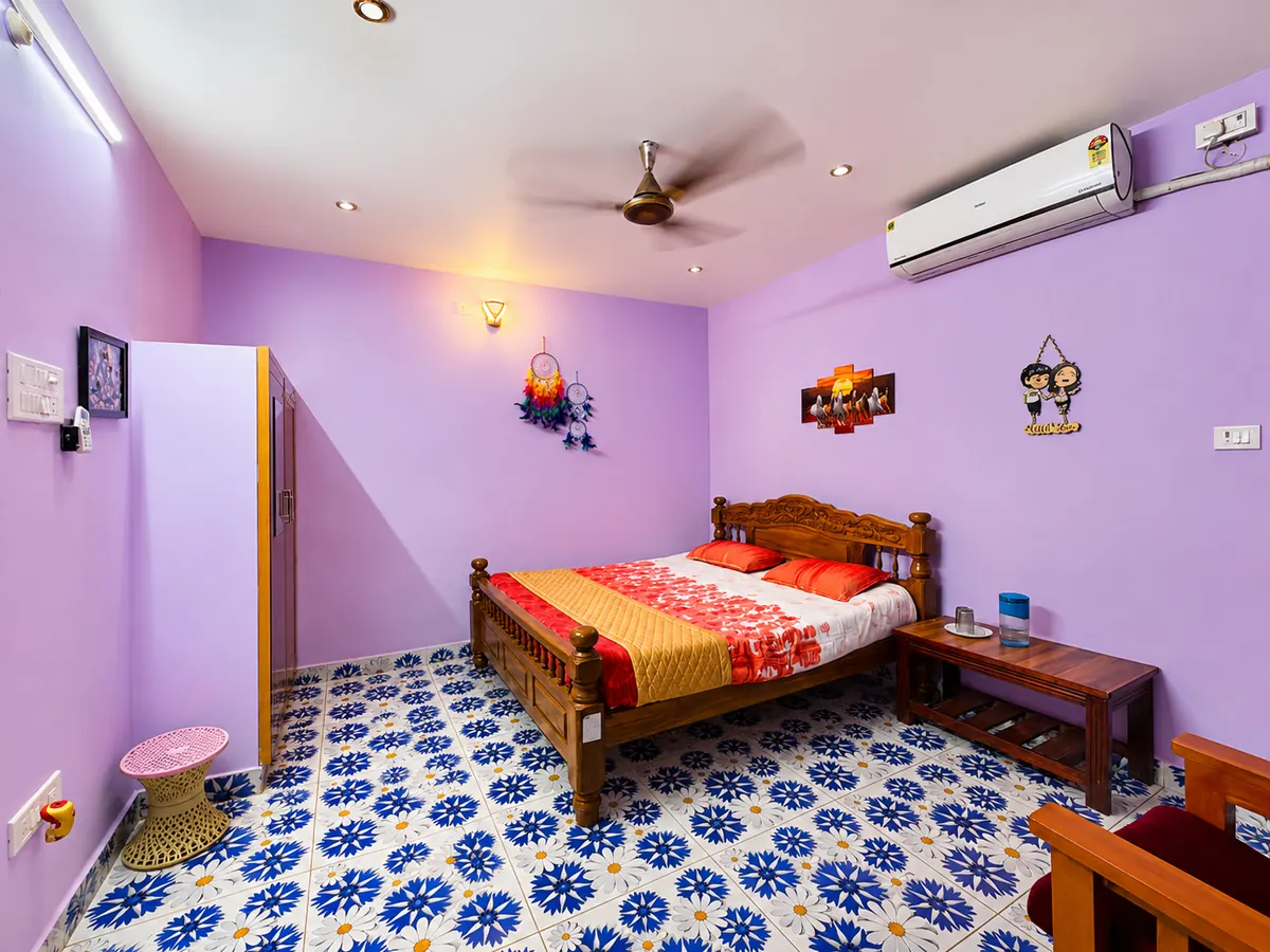 Bedroom with wooden bed and air conditioner in a Re Leaf Resort cottage